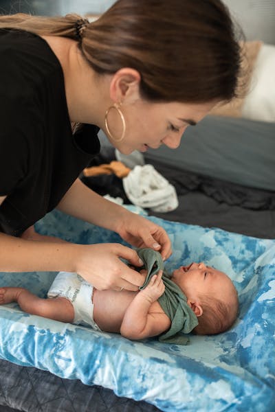 Žena převléká miminko